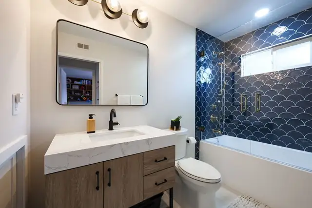 Scripps Ranch guest bath with wood vanity, quartz counter and navy fish-scale tile tub surround
