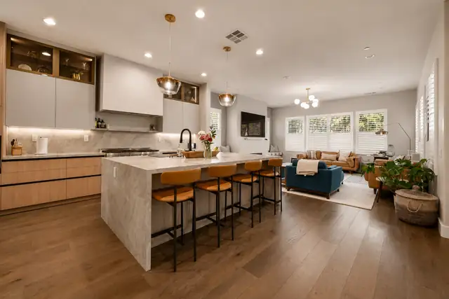 Complete home remodel by Craft with a waterfall island, leather counter stools and an open living room