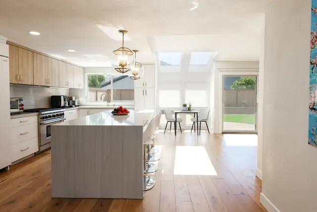 Complete home remodel in Rancho Santa Fe, CA with open kitchen, light oak cabinets and quartz waterfall island