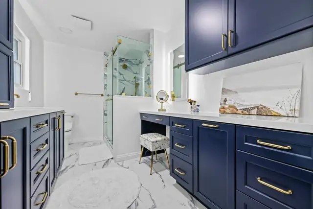 Spacious primary bath remodel in San Diego with navy cabinetry and gold hardware
