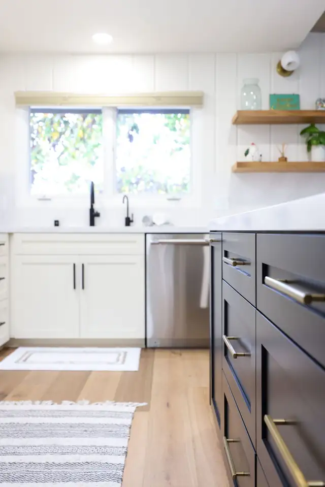 Kitchen remodel in La Jolla, CA with white shaker cabinets, navy island, brass pulls and floating wood shelves